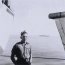 Bill Hartland on HMS Tyne with HM Yacht Britannia in background